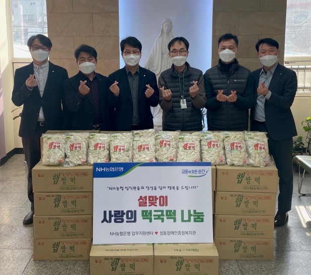 지난 21일 농협은행 이수환 경영지원부문 부행장(왼쪽에서 세번째)과 정진영 성동장애인종합복지관 국장(왼쪽에서 네번째), 농협은행 업무지원센터 직원들이 '사랑의 떡국떡 나눔 행사'에서 기념촬영을 하고 있다. 사진=NH농협은행