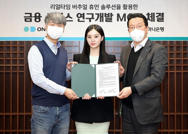 하나은행은 지난 13일 오후 서울 중구 을지로 하나은행 본점에서 버추얼 휴먼 솔루션 기업 온마인드와 전략적 업무협약을 체결했다. 황보현우 하나은행 데이터&제휴투자본부 본부장(사진 오른쪽), 김형일 온마인드 대표이사(사진 왼쪽), 가상인간 나수아(사진 가운데)가 기념촬영을 하고 있다. 사진=하나은행