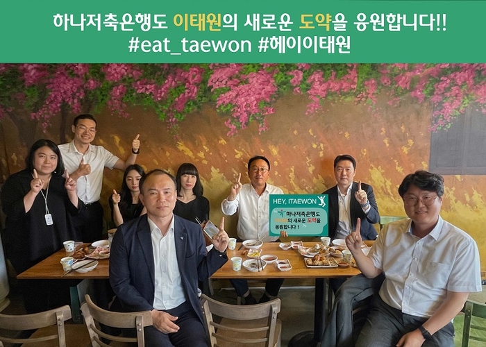 하나저축은행 정민식 대표이사가 이태원 지역 상권 살리기 프로젝트인 '헤이, 이태원 회식 챌린지'에 동참했다. 이태원의 한 식당에서 정 대표(뒷줄 오른쪽 두 번째)가 임직원과 저녁식사를 하며 '헤이, 이태원 회식 챌린지' 손팻말 옆에서 기념촬영하고 있다. 사진=하나은행