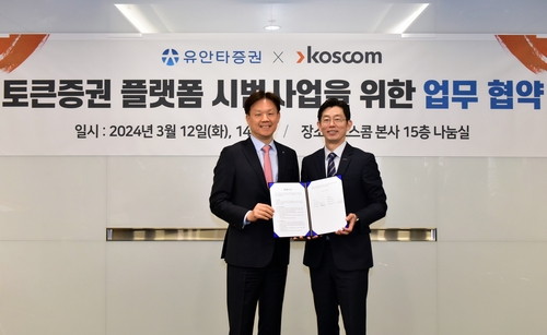 코스콤 황선정 전무이사(우)와 유안타증권 Retail사업부문 신남석 대표가 업무협약을 체결하고 기념사진을 촬영하고 있다. 사진=코스콤.