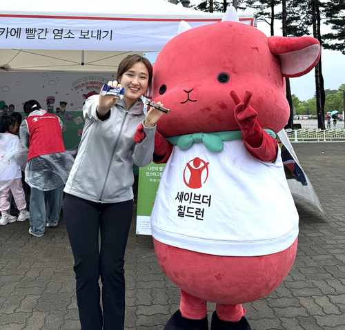 2024국제어린이마라톤 현장에서 롯데웰푸드단백질바를 들고 기념사진을 찍고 있다. 사진=롯데웰푸드.