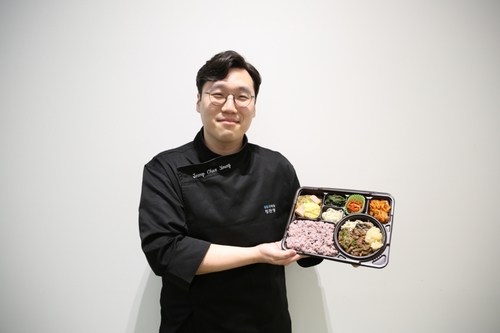 GS리테일 식품개발팀 연구원이 추석 소불고기 전골 도시락을 들고있다. 사진=GS리테일.
